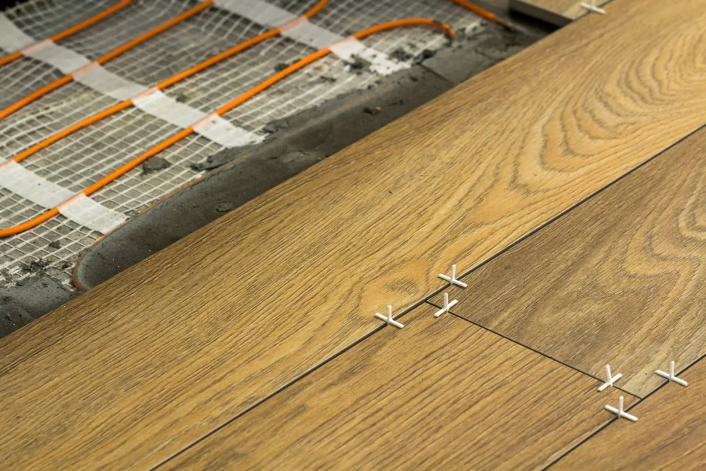 Installation d'un plancher chauffant en céramique imitation bois franc.